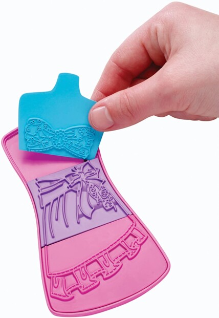 Atelier créatif Barbie avec étui et plaques de motifs, main tenant une pièce turquoise