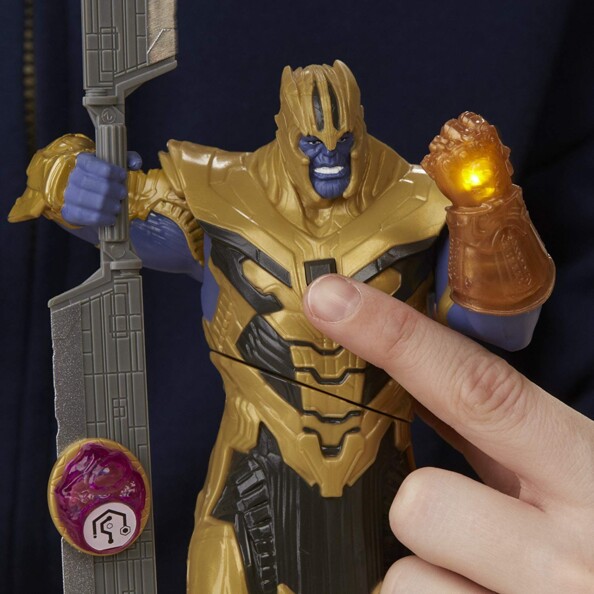 Doigt appuyant sur le torse de la figurine Thanos pour activer le gant lumineux Hasbro Avengers
