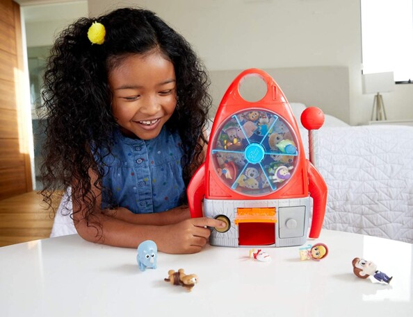 Une petite fille qui s'amuse avec sa fusée/machine à sous Pizza Planet Toy Story.