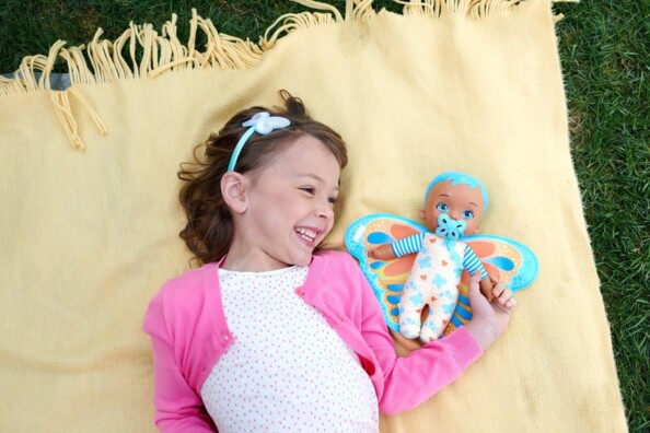 Petite fille couchée avec jouet bébé papillon à côté