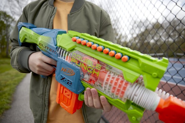 Lanceur motorisé Nerf Double Punch tenu par un enfant en extérieur, mise en situation de tir