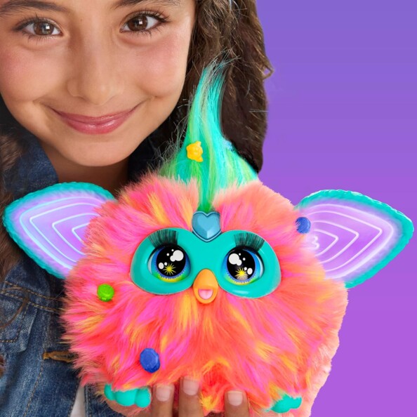 Animal interactif Furby tenu par une jeune fille en veste en jean, mise en situation