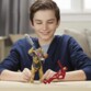 Enfant tenant les figurines Thanos et Iron Man sur une table en bois, coffret Avengers