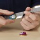 Deux mains tenant l’épée grise et les pierres d’infinité bleue et violette du coffret Avengers