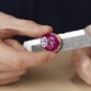 Gros plan sur deux mains manipulant la pierre violette et l’épée du coffret Infinity War