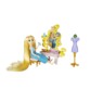 Poupée Raiponce assise sur tabouret rose devant coiffeuse ornée de volutes dorées avec brosse et accessoires