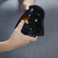 Casque Simon Star Wars Dark Vador allumé avec œil orange, tenu par deux mains