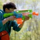 Blaster Nerf Elite 2.0 Double Punch utilisé par un enfant avec lunettes, tir en extérieur