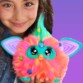 Animal interactif Furby tenu par une jeune fille en veste en jean, mise en situation